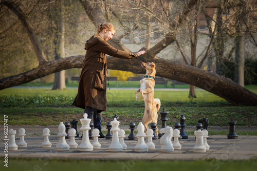 Obraz na płótnie Beautiful girl and little red dog and big chess w salonie