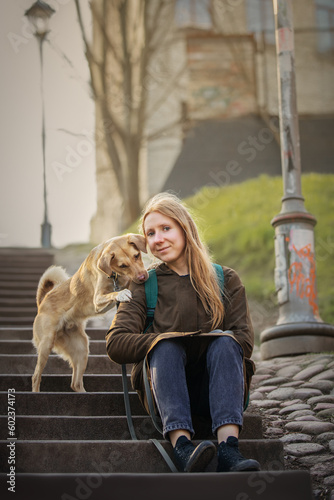 Beautiful blonde girl with dog in the city