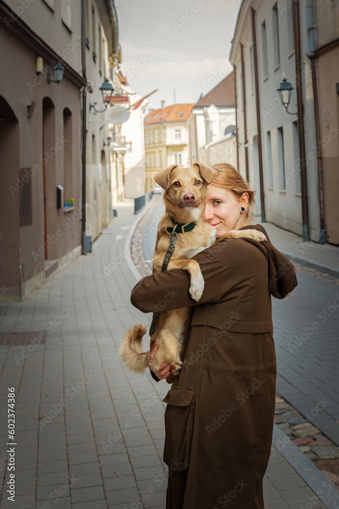 Beautiful blonde girl with dog in the city
