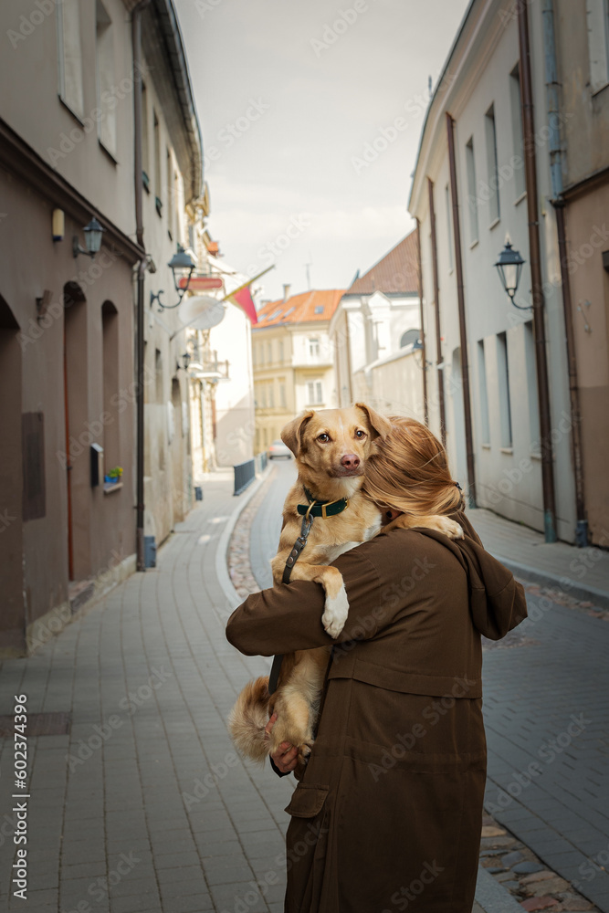 Beautiful blonde girl with dog in the city