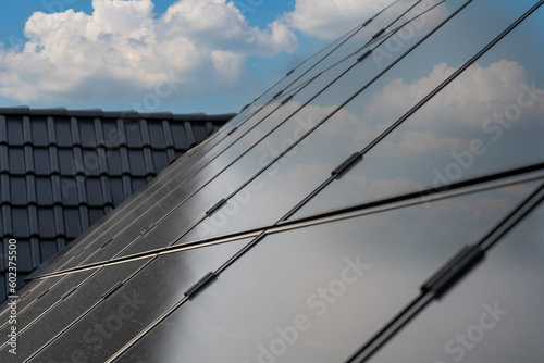 Diese PV-Anlage auf dem Dach einer modernen Wohnanlage nutzt die Kraft der Sonne, um erneuerbare Energie zu erzeugen. Die Solarpanels fangen das Sonnenlicht ein und wandeln es in saubere, grüne Energi photo