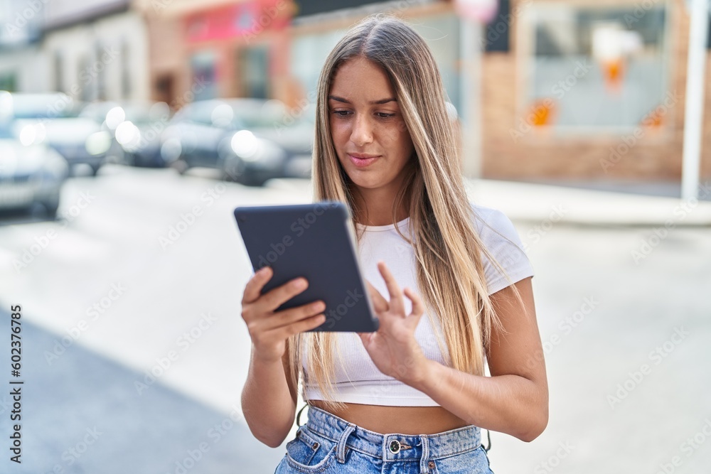 Young beautiful hispanic woman using touchpad at street Young beautiful hispanic woman using touchpad at street