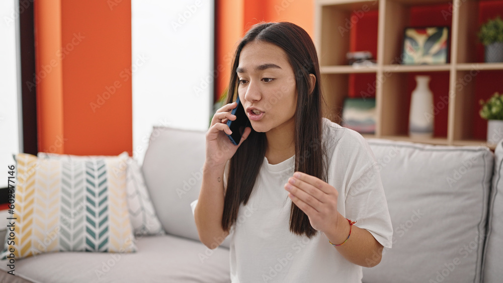 Young beautiful hispanic woman talking on smartphone with unhappy expression at home Young beautiful hispanic woman talking on smartphone with unhappy expression at home