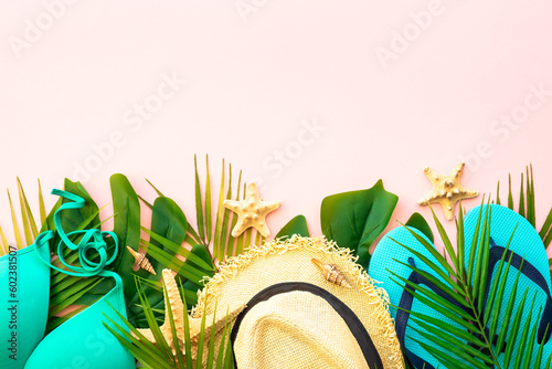 Summer flat lay background. Palm leaves, sea shells and summer cloth on pink background.