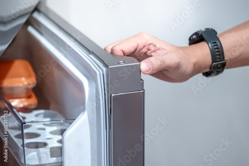 Canvastavla Male hand opening refrigerator or fridge door at home decor showroom