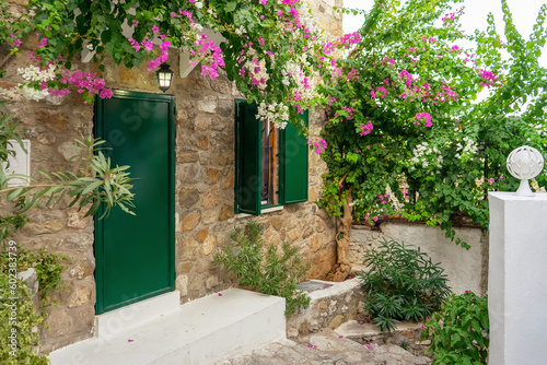 Fototapeta Naklejka Na Ścianę i Meble -  Beautiful courtyard of an old brick house in old town with blooming pink flowers of bougainvillea. Travel, vacation concept. European architecture
