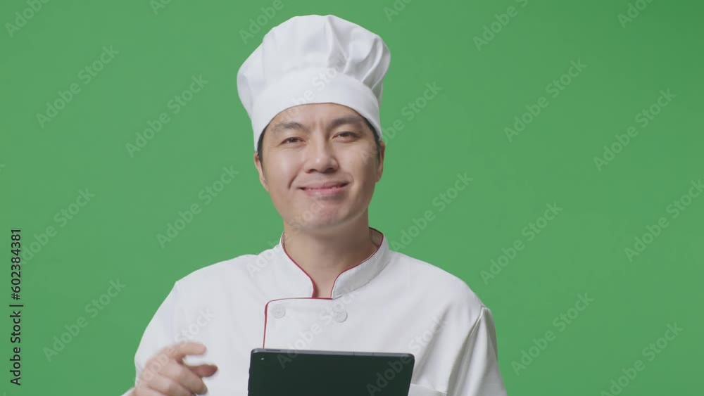 Close Up Of Asian Man Chef Smiling And Pointing To Tablet In His Hand While Standing In The Green Screen Background Studio
Close Up Of Asian Man Chef Smiling And Pointing To Tablet In His Hand While Standing In The Green Screen Background Studio