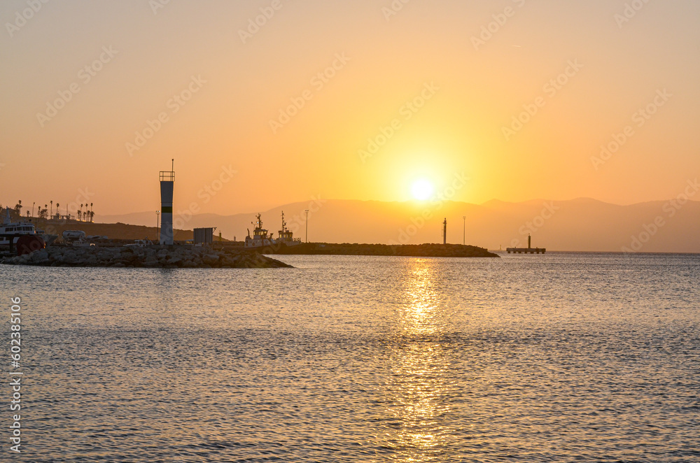 Cesme harbor lighthouse at sunset (Izmir province, Turkiye)
