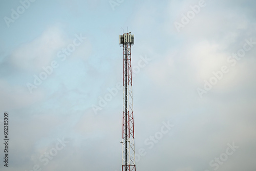 A cell phone tower with a dark sky behind it.