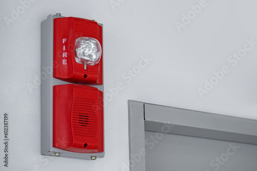 Fire alarm with built in emergency strobe light and sounder installed on the wall in public building. photo