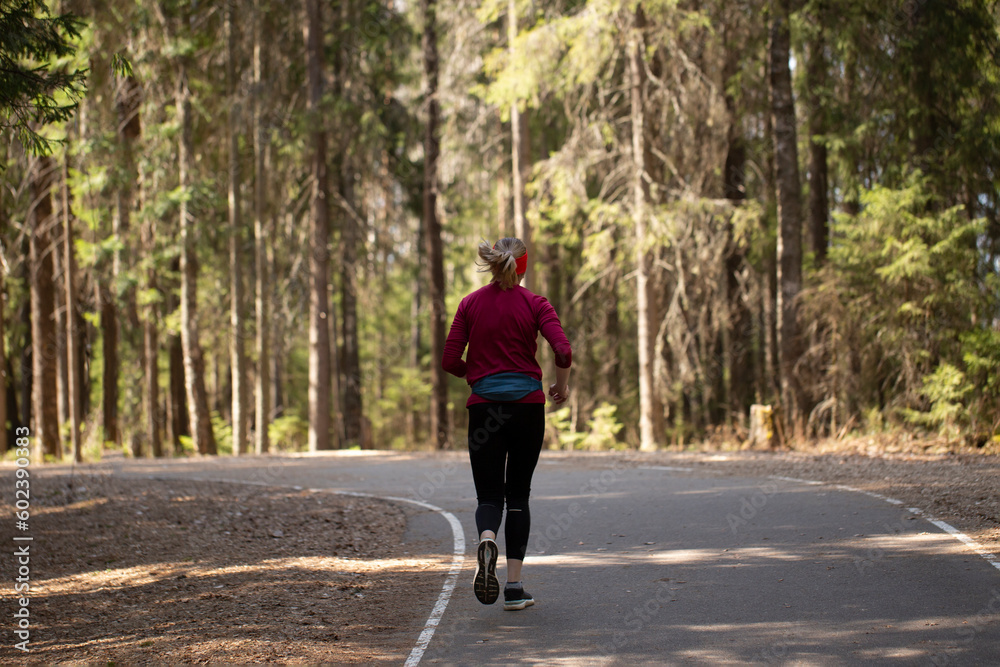 A young woman runs around the spring park.Outdoor activity.