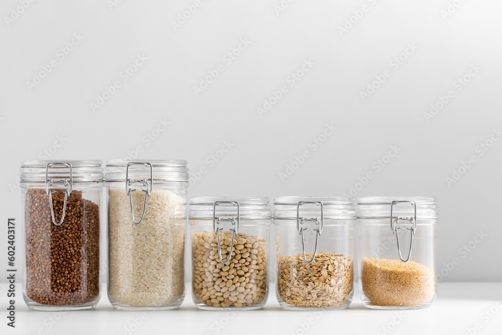 food, healthy eating and diet concept - jars with buckwheat, rice, oat flakes, couscous and beans on white background food, healthy eating and diet concept - jars with buckwheat, rice, oat flakes, couscous and beans on white background