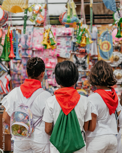 three children with their backs turned, choosing a toy at a colorful flea market stall. concept of childhood and happiness.