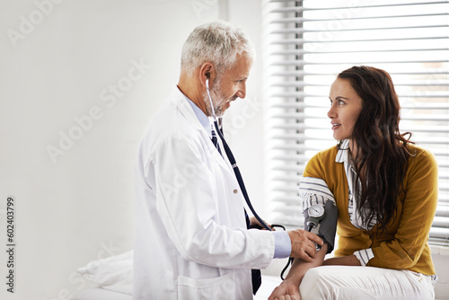Blood pressure, doctor and a woman patient at hospital for a consultation with health insurance. Man with a stethoscope to check pulse of person for medical exam, wellness and hypertension diagnosis photo