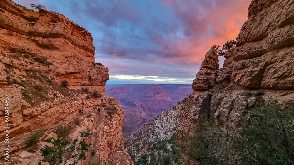 Panoramic aerial view from Bright Angel hiking trail at South Rim of Grand Canyon National Park, Arizona, USA. Vista after sunrise in summer. Sky is shining in vivid orange red colors