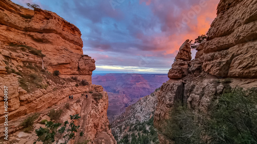 Panoramic aerial view from Bright Angel hiking trail at South Rim of Grand Canyon National Park, Arizona, USA. Vista after sunrise in summer. Sky is shining in vivid orange red colors