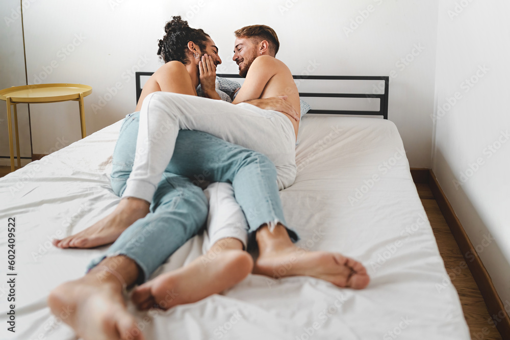 Intimate Young Gay Couple on Bed - A shirtless young gay couple in jeans, lying on the bed, gazing into each other's eyes and cuddling. Intimate Young Gay Couple on Bed - A shirtless young gay couple in jeans, lying on the bed, gazing into each other's eyes and cuddling.