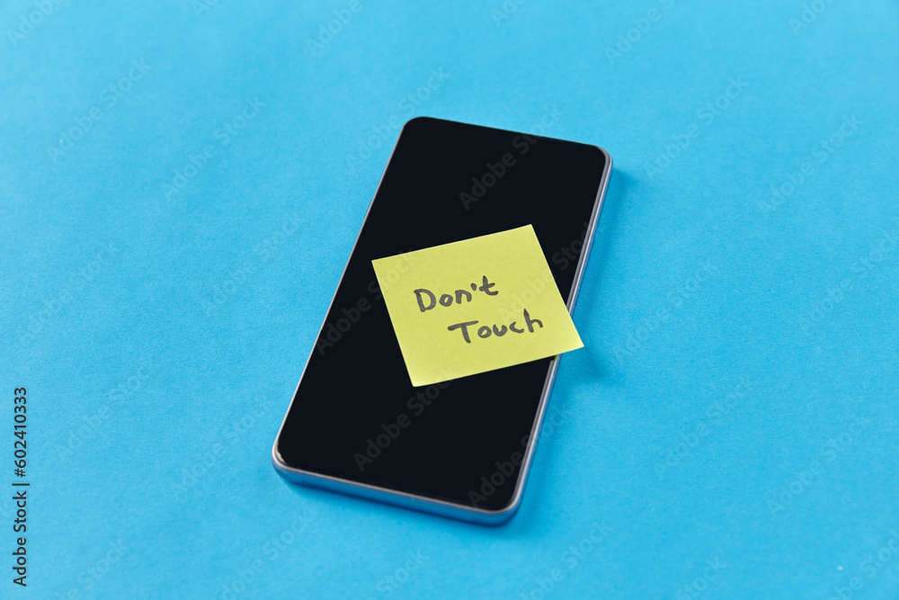 privacy, technology and digital detox concept - close up of smartphone with don't touch words on sticky note on blue background privacy, technology and digital detox concept - close up of smartphone with don't touch words on sticky note on blue background