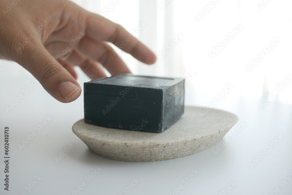 hand reaching for natural soap bar on table hand reaching for natural soap bar on table