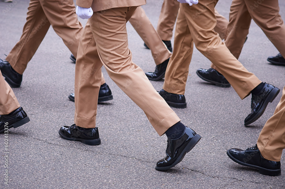March on the parade of warriors in black patent leather boots. Light sand-colored dress uniform. Selective focus. March on the parade of warriors in black patent leather boots. Light sand-colored dress uniform. Selective focus.