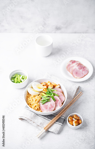 Ramen noodle with meat slices, fried Tofu, eggs and scallions in a bowl