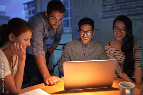 Teamwork  night and a business group on a laptop  working in the boardroom for planning  strategy or innovation. Meeting  collaboration and overtime with a team of employees at work in the evening