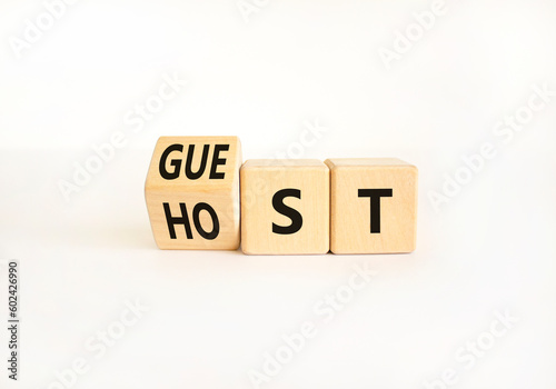 Guest and host symbol. Businessman turns wooden cubes and changes the word Guest to Host. Beautiful white table white background. Business guest and host concept. Copy space.