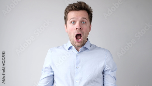 Foto European young man is greatly surprised and opens his mouth in astonishment