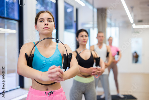 Portrait of young woman maintaining physical health practicing pilates with fitness circle