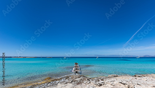Ses Illestes beach, on the island of Formentera. Wooden jetty on transparent turquoise waters. photo