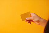 Female hand holding bank credit card on a yellow background, generative ai