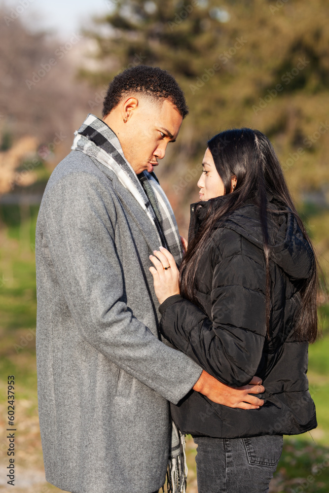 Man and woman posing in the park. Multiracial couple in love. Man and woman posing in the park. Multiracial couple in love.
