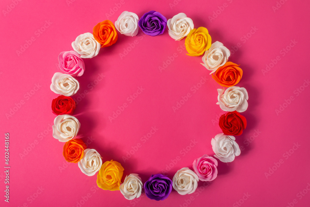 Round frame, wreath, circlet of multicolored soap roses on bright pink background, top view, flat lay. The concept of skin care, beauty, love, Valentine's Day. Round frame, wreath, circlet of multicolored soap roses on bright pink background, top view, flat lay. The concept of skin care, beauty, love, Valentine's Day.