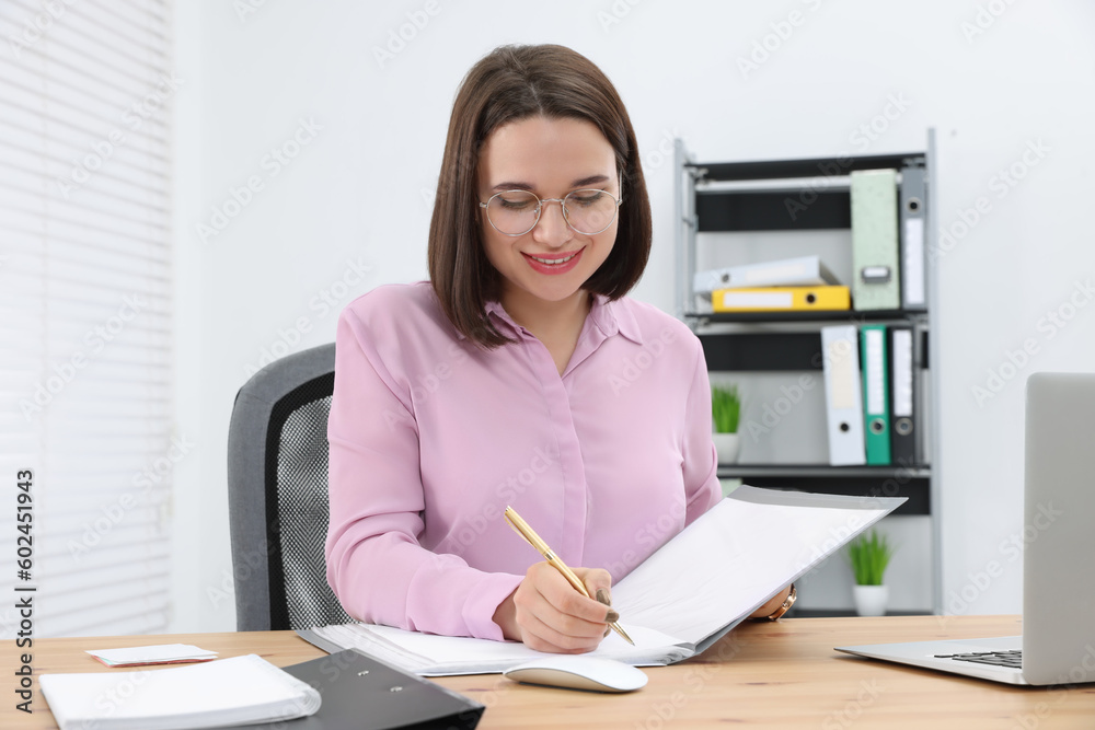Happy young intern working at table in modern office Happy young intern working at table in modern office