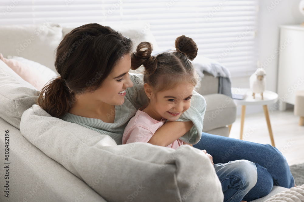 Young mother and her daughter spending time together on sofa at home Young mother and her daughter spending time together on sofa at home