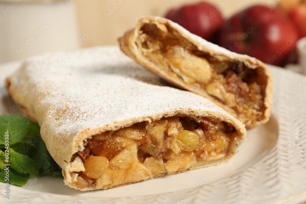 Delicious strudel with apples, nuts and raisins on plate, closeup Delicious strudel with apples, nuts and raisins on plate, closeup