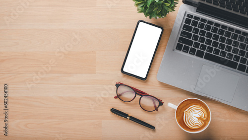 Office desk workplace with blank screen smartphone  laptop  eyeglass  pen and cup of coffee  Top view flat lay with copy space.