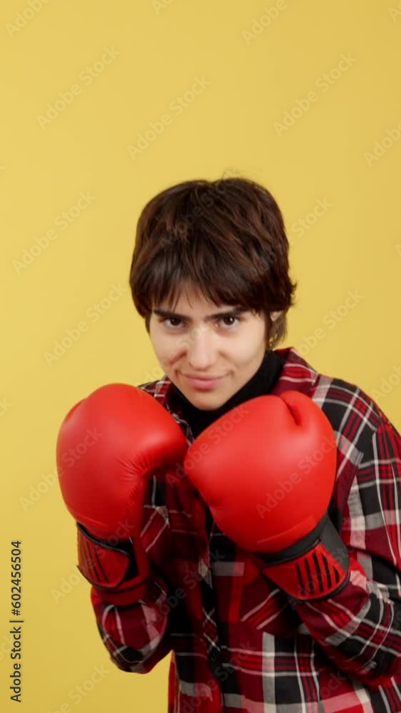 Non binary person with boxing gloves in fight pose Non binary person with boxing gloves in fight pose