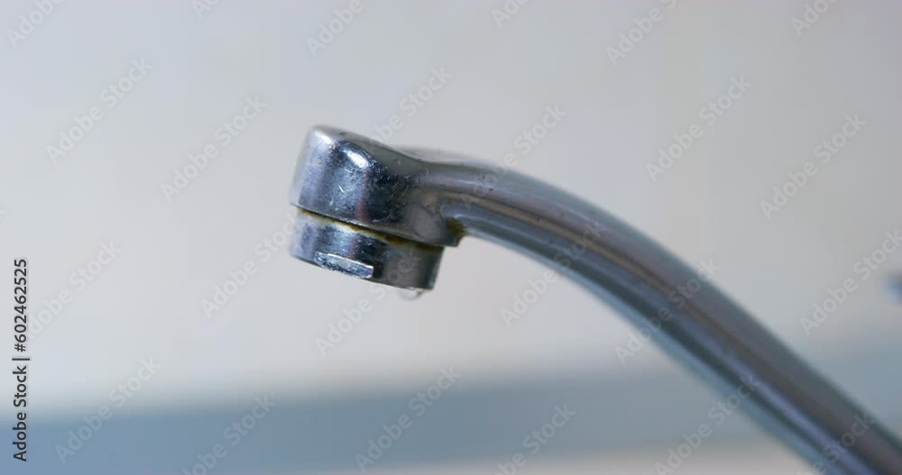 Close-up chrome steel faucet plumbing repair breakage drop dripping.Leakage of water Waste of resources Scarcity of resources. Reasonable consumption savings . Faulty old plumbing. Water consumption Close-up chrome steel faucet plumbing repair breakage drop dripping.Leakage of water Waste of resources Scarcity of resources. Reasonable consumption savings . Faulty old plumbing. Water consumption
