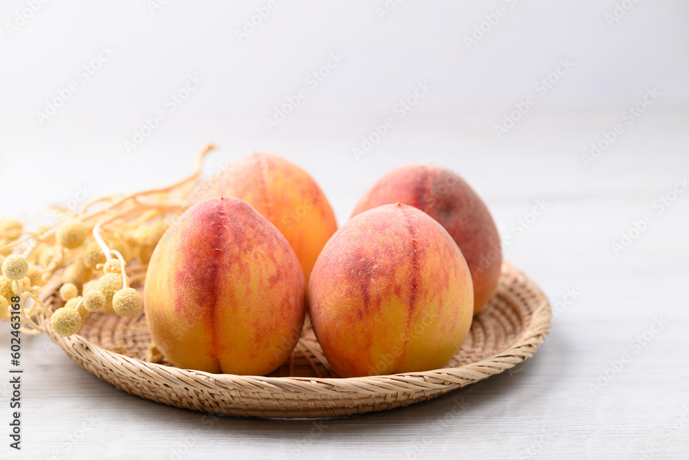 Ripe Peaches fruit in basket on white table Ripe Peaches fruit in basket on white table