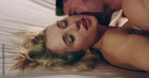 Sexy couple, bedroom and kissing for foreplay in a house, apartment or hotel. Man and woman together on bed while intimate, making love or sex for passion, affection and lust or erotic experience