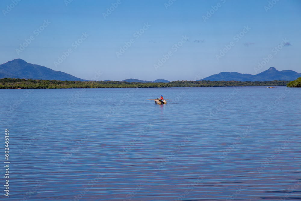 Naklejka premium Aerial view of the city of Cananéia. Mangrove and sea in Ilha do Cardoso State Park. With man fishing in a boat