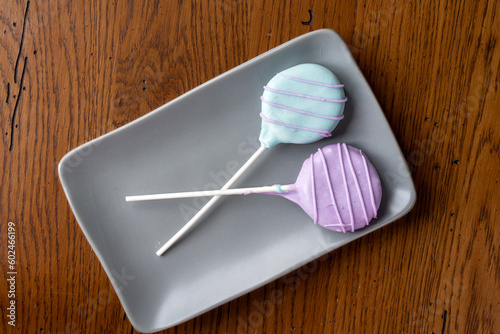 Colorful homemade cake pops on a gray plate.