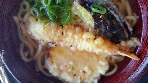 Top view slowmotion video udon jpanese noodle hot soup with tempura shrimp eggplant sweet jam local healthy food photo
