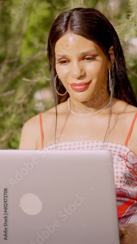 Transgender woman working with laptop outdoors
