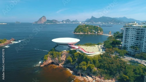 RIO DE JANEIRO, BRASIL - MAY, 2023: Drone aerial view of of a famous landmark modern art museum in Niteroi district and Guanabara Bay. Modern buildings on the shore on background at sunny day.