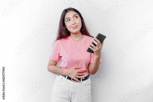 An Asian woman is hungry or having menstruation or stomach ache, touching her belly and her phone