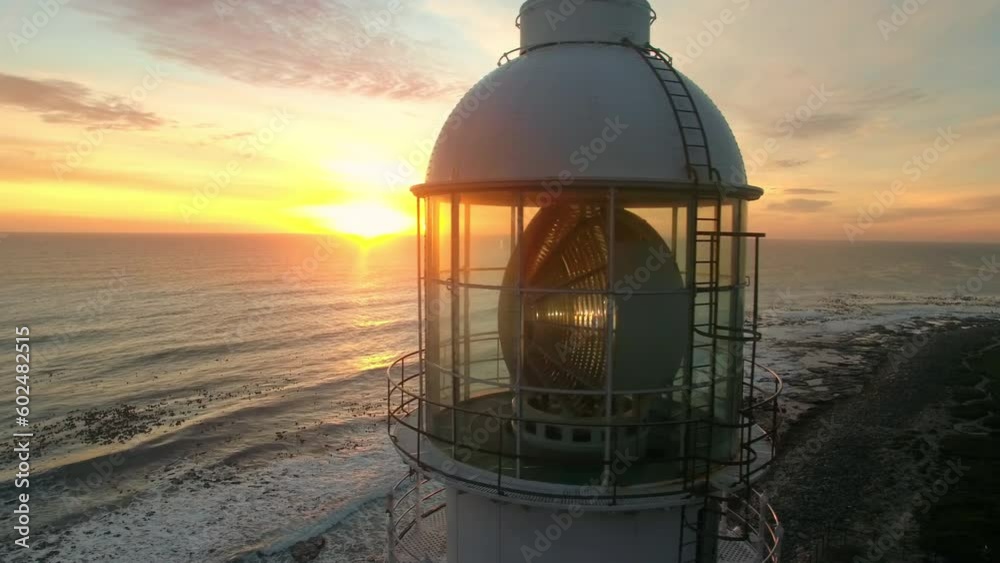 Aerial, drone and lighthouse at the ocean on a sunset sky at night or morning sunrise. Landscape of a light or spotlight at the beach for direction, safety or navigation and security in silhouette