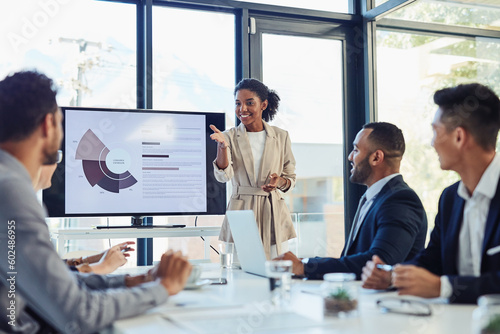 Business meeting, businesswoman and presentation on screen of tv in modern boardroom with colleagues. Workshop, speech and black woman or speaker speaking with coworkers in conference room photo