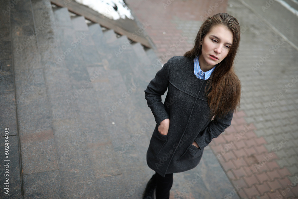 Young adult girl in coat on the street